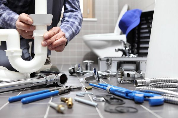 plumber-working-in-bathroom-reg4-99466254